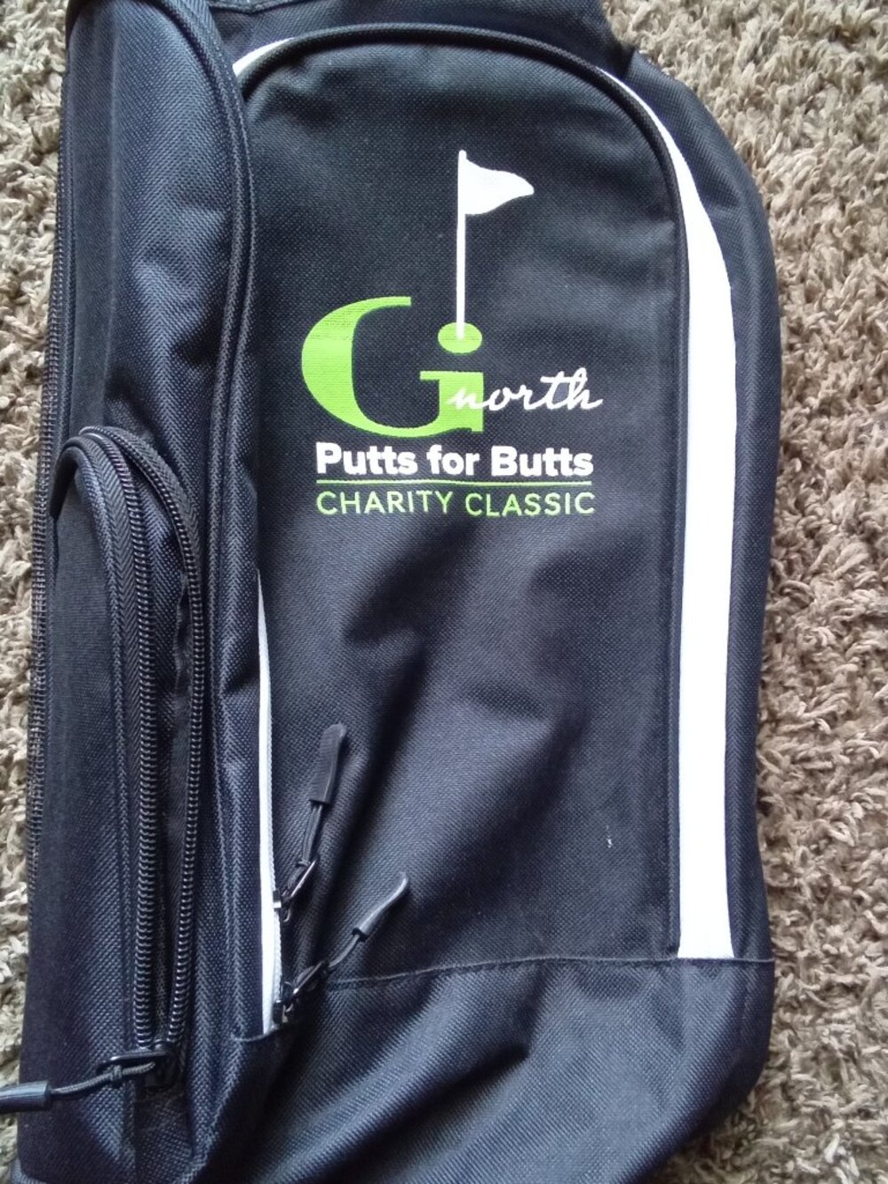 Durable black golf shoe bag featuring green logo accent. Lightweight and easy to
